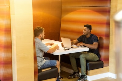 An image showcasing two individuals engaged in a constructive conversation, surrounded by stacks of paperwork representing debt settlement options