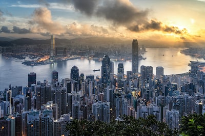 An image showcasing the skyline of Hong Kong at dusk, with the city's iconic skyscrapers reflecting in the Victoria Harbour